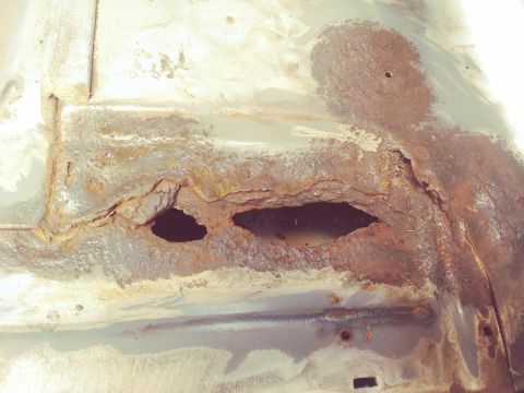 1996 Ford Bronco - Significant rust damage has created holes in the vehicle's floor pan, indicating severe corrosion.