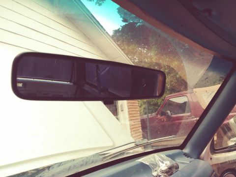 1996 Ford Bronco - Reflection in the rearview mirror shows a red pickup truck outside the vehicle.