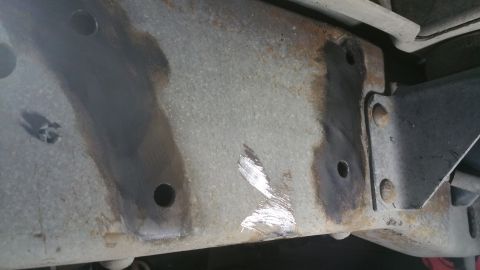 1996 Ford Bronco - Close-up of a rusted vehicle frame section, showing bolt holes and some scraped metal. The Supermotors.net logo is visible in the lower rig…