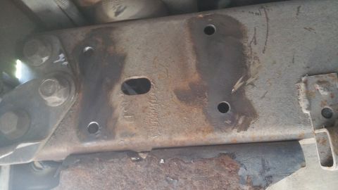 1996 Ford Bronco - Close-up view of a heavily rusted metal frame component with visible bolt holes.