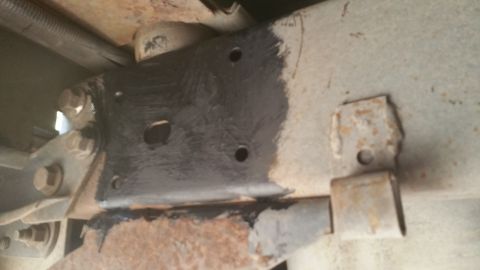 1996 Ford Bronco - This image shows a close-up view of a vehicle's undercarriage, focusing on the frame and suspension components with signs of rust and recen…