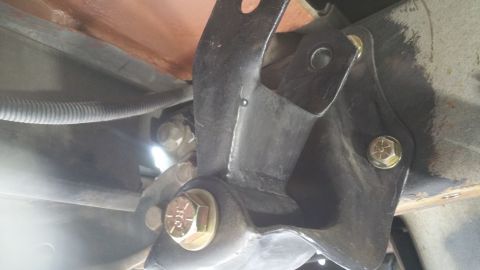 1996 Ford Bronco - Underside view of vehicle suspension hardware, showing mounting brackets and fasteners.