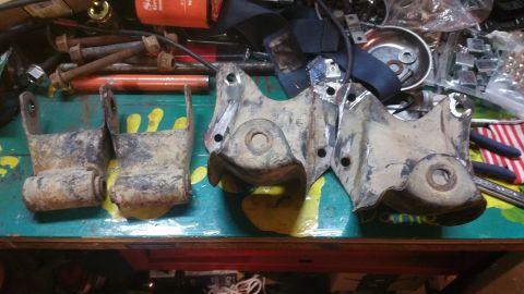 1996 Ford Bronco - Used Ford Bronco rear suspension parts and hardware laid out on a workbench.