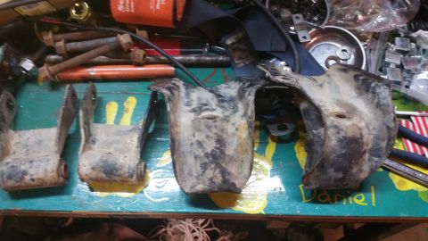 1996 Ford Bronco - Several used vehicle suspension components are displayed on a workbench alongside various tools and hardware.