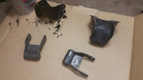 1996 Ford Bronco - Painted suspension parts laid out on cardboard, possibly for a vehicle repair or restoration project.