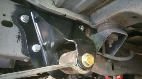 1996 Ford Bronco - Close-up view of a black suspension bracket and hardware on the underside of a vehicle.