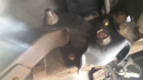 1996 Ford Bronco - Underside view of vehicle's rear suspension hardware, showing various metal components and fasteners.