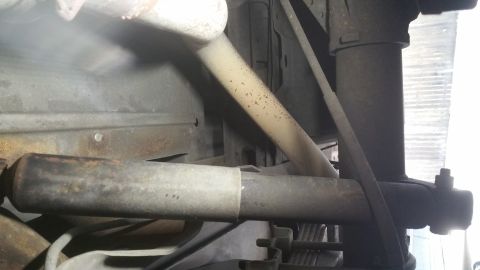 1996 Ford Bronco - Underside view of vehicle rear suspension components, including a shock absorber and exhaust pipe.