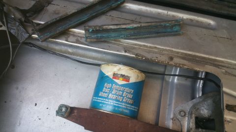 1996 Ford Bronco - can of LubriMatic High Temperature Disc/Drum Brake Wheel Bearing Grease sitting on a metal panel with green grease.