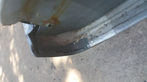 1996 Ford Bronco - A close-up view of a damaged vehicle body panel shows rust and gray sealant applied to a cracked area.