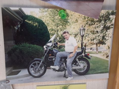 1994 Ford Bronco - Man poses on a motorcycle parked in front of a house.