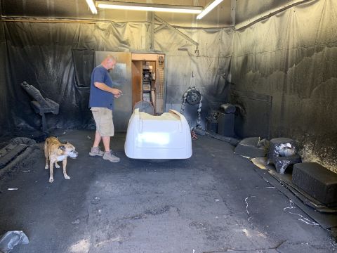 1923 Ford Model T - A man and his dog are in a spray booth with a white car body part.
