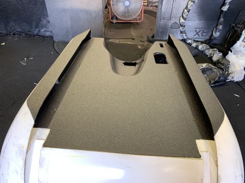 1923 Ford Model T - A car hood with a textured surface and cutouts is shown, with a fan visible in the background.