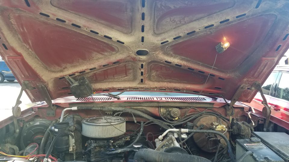 Engine bay with hood open. Shows engine, air filter, and wiring