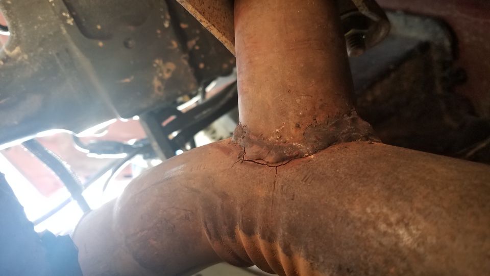 Cracked exhaust pipe weld, rusty metal