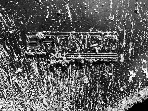 1996 Ford Bronco - A close-up of a mud-covered Bronco badge.