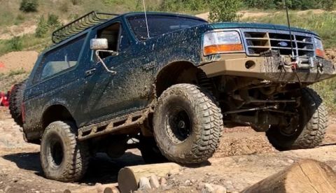 1996 Ford Bronco - This 1996 Ford Bronco navigates a challenging off-road course, covered in mud from its adventure.