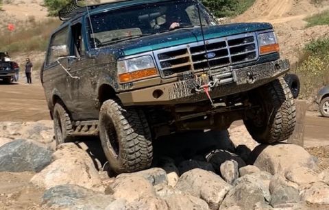 1996 Ford Bronco - This Ford Bronco is navigating a challenging rocky terrain during an off-road excursion.