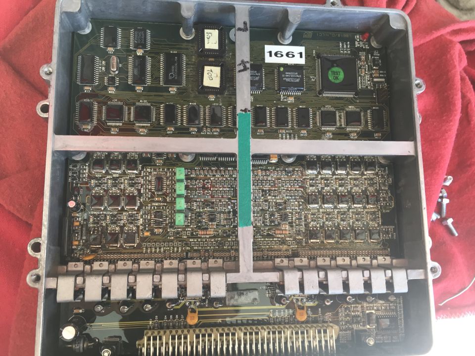 Open engine control unit with circuit boards and chips visible. Label '1661' is on one of the boards