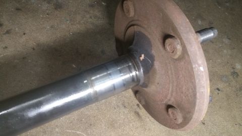 1996 Ford Bronco - A close-up view shows a rusty brake drum or hub assembly attached to a metal axle shaft. The assembly has several bolts and a threaded stud…