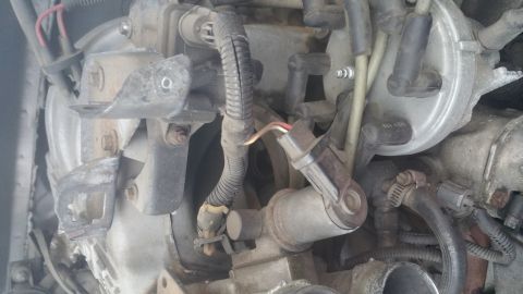1996 Ford Bronco - A close-up view of the engine bay of a 1996 Ford Bronco, showing various engine components including spark plug wires, a distributor cap, a…