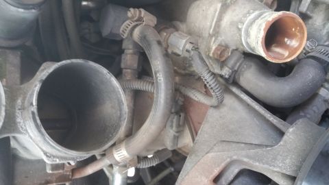 1996 Ford Bronco - This is a close-up engine bay view of a 1996 Ford Bronco, focusing on the throttle body and coolant hoses. The engine appears to be a V8, w…