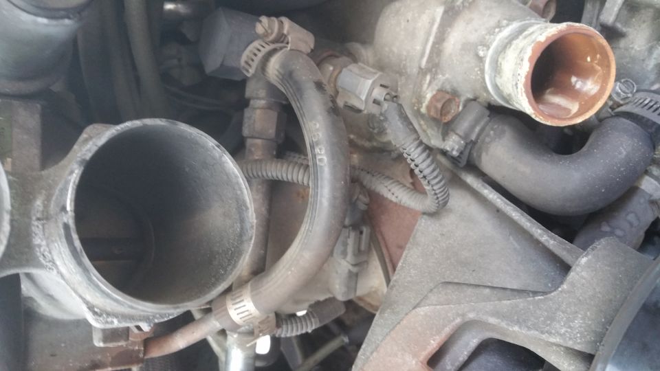 Close-up of 1996 Ford Bronco engine bay showing throttle body and coolant hoses.