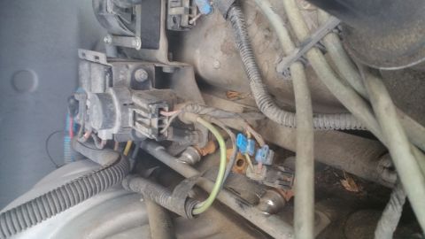 1996 Ford Bronco - A close-up view of the engine bay of a 1996 Ford Bronco, showing various electrical connectors, wiring harnesses, and engine components cov…