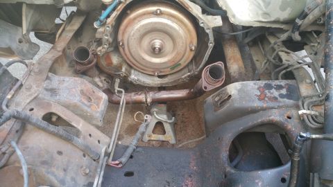 1996 Ford Bronco - This is a close-up view of the engine bay of a 1996 Ford Bronco, showing the transmission bell housing, torque converter, and exhaust pipes…