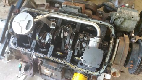 1996 Ford Bronco - The internal components of an engine are visible, including the crankshaft, connecting rods, and oil pump. A silver oil pickup screen is al…