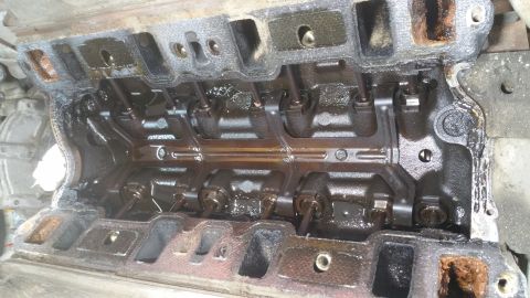 1996 Ford Bronco - This is a close-up, overhead view of the inside of an engine's cylinder head, showing the valve train components covered in oil. The metal…