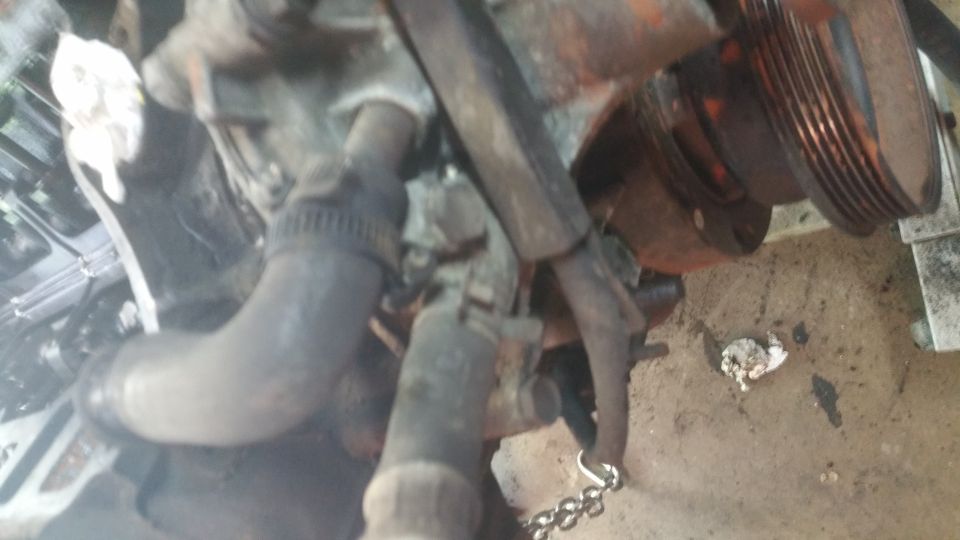 Engine part with hose and pulley, chain attached