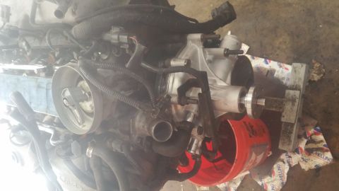 1996 Ford Bronco - This is a close-up, overhead view of a vehicle engine, likely from a 1996 Ford Bronco, showing various components including the throttle bo…
