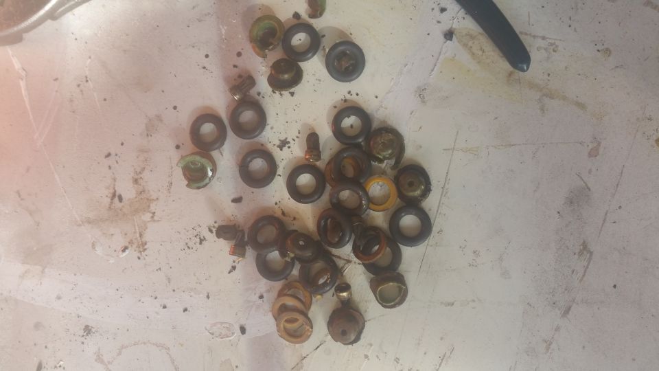 Pile of assorted small metal and rubber washers and seals on a textured surface