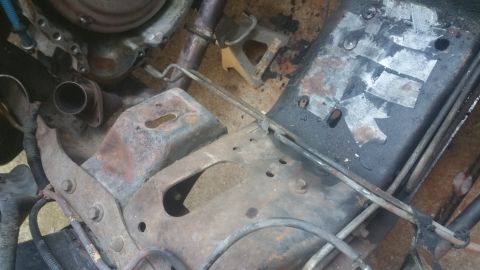 1996 Ford Bronco - A close-up view shows the rusty undercarriage of a vehicle, including parts of the engine, exhaust pipe, and frame. Metal components are he…