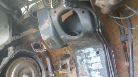 1996 Ford Bronco - This image shows the underside of a vehicle, focusing on the transmission, exhaust pipe, and part of the frame. The components are heavily…