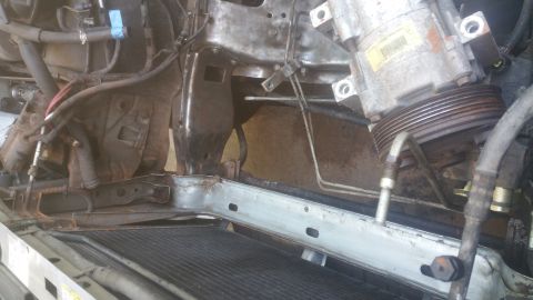 1996 Ford Bronco - The image shows a close-up view of the engine bay of a 1996 Ford Bronco, focusing on the air conditioning compressor and radiator assembly.…