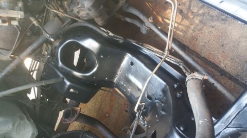 1996 Ford Bronco - A close-up view of the underside of a vehicle's frame, which has been recently painted black. Various hoses, metal lines, and exhaust compo…