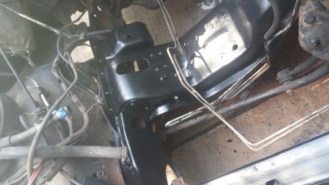 1996 Ford Bronco - The underside of a vehicle frame, likely a 1996 Ford Bronco, has been painted black. Visible components include fuel or brake lines, wiring…