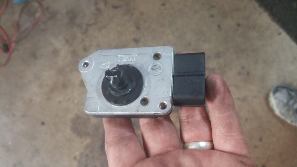 Silver mass air flow sensor with black connector, showing "NGK" and "F3" markings.