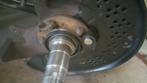 1996 Ford Bronco - A close-up view of a vehicle's wheel hub assembly, showing a brake rotor with numerous holes, a bearing seal, and a sensor attached to the…