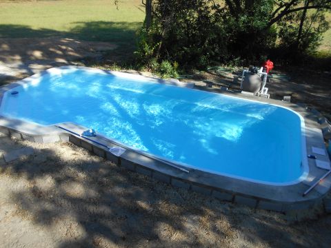 1992 Ford Bronco - A newly installed swimming pool is shown with a pool pump and filter system in the background. The pool is filled with bright blue water an…