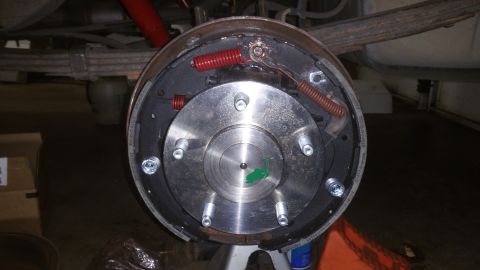 1996 Ford Bronco - A close-up view of the rear drum brake assembly of a vehicle, showing the brake shoes, springs, and hub. The vehicle appears to be on a jac…