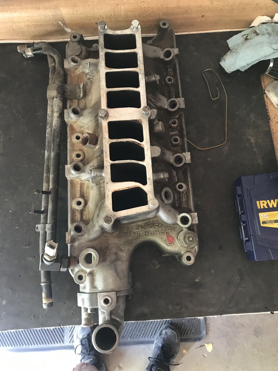 Ford Explorer intake manifold with attached tubing on a dark surface.