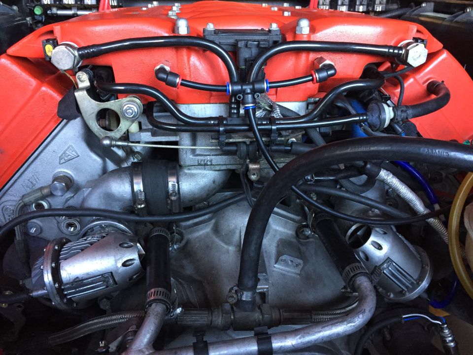 Lotus Esprit engine bay with orange intake manifold and turbo components.