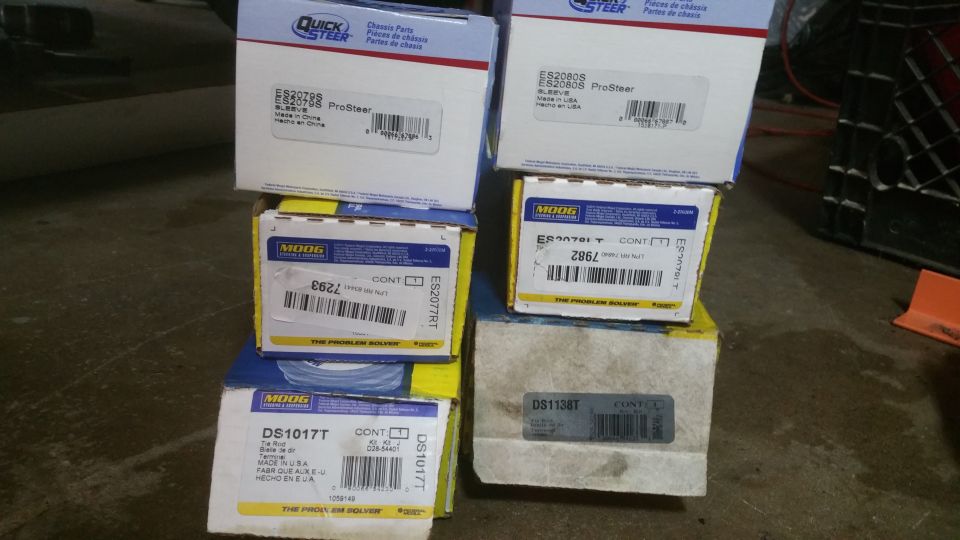 Stack of automotive parts boxes from QuickSteer and Moog.