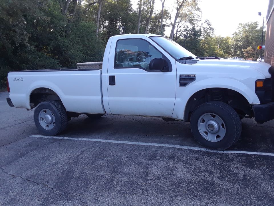 White 2008 Ford F-350 pickup truck, side view, with a toolbox in the bed.