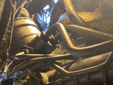 Engine bay of a 2000 Pontiac Grand Prix with metal tubes and engine parts.