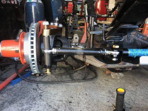1992 Jeep Wrangler - A close-up view of the front suspension and steering components of a vehicle, likely a Jeep Wrangler, showing a disc brake assembly, tie ro…
