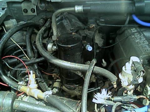 1989 Ford Bronco - Close-up view of an engine bay with various hoses and mechanical parts visible.